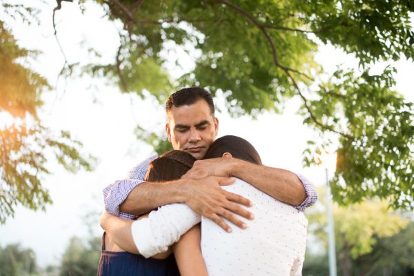man hugging his family