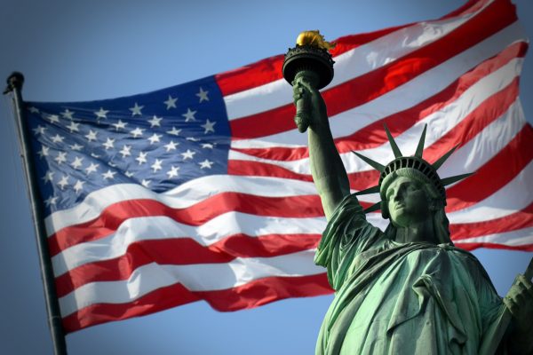 statue of liberty if front of US flag
